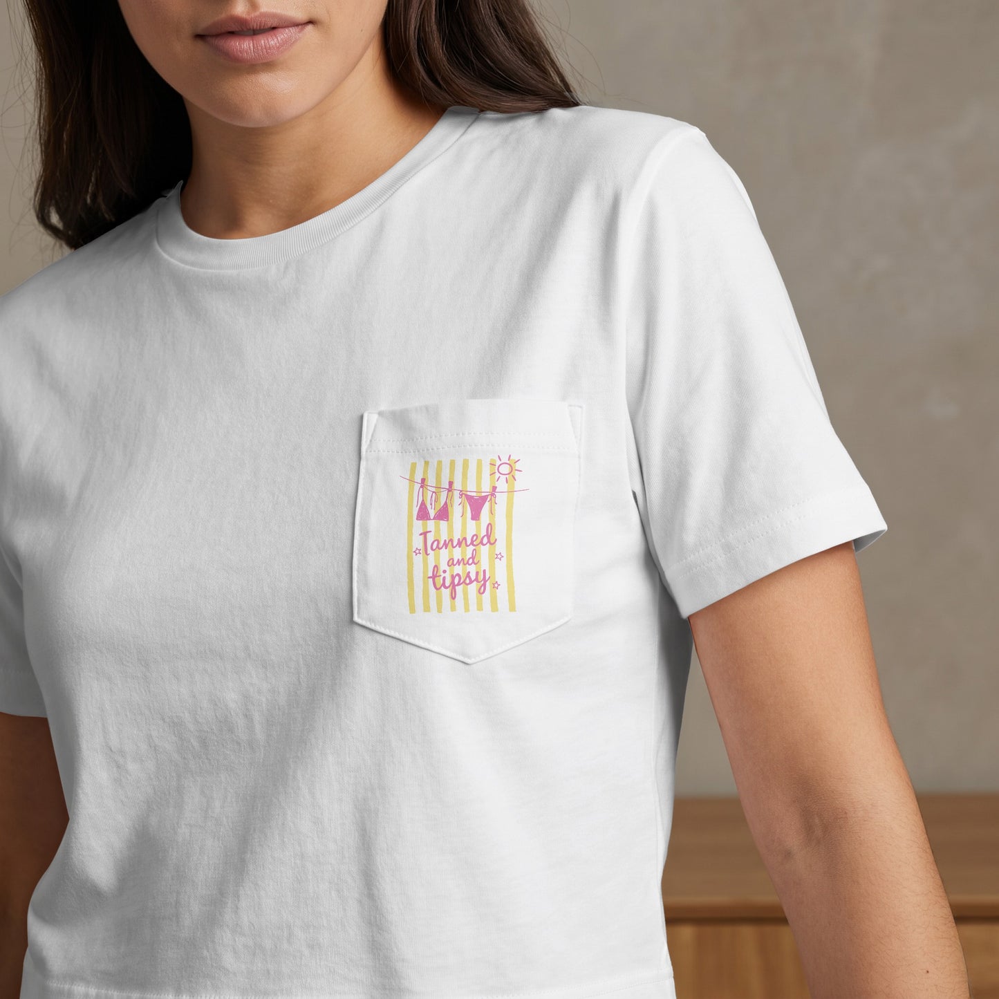 White t-shirt with pink and yellow striped pocket graphic and text.