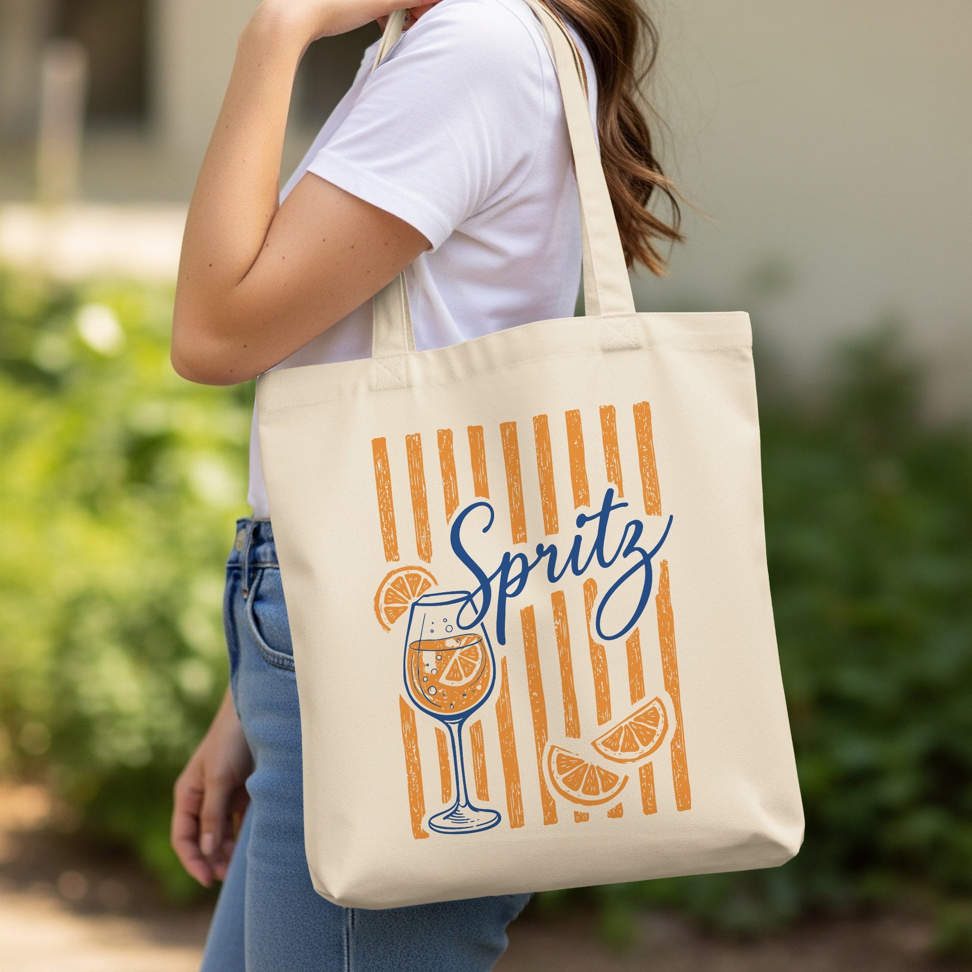 Cream tote bag with orange stripes and "Spritz" text, featuring a drink and orange slices.